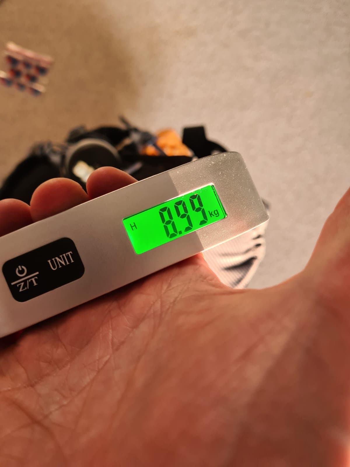 Luggage scale showing the MdS pack weighing 8.99kg at the final weigh-in
