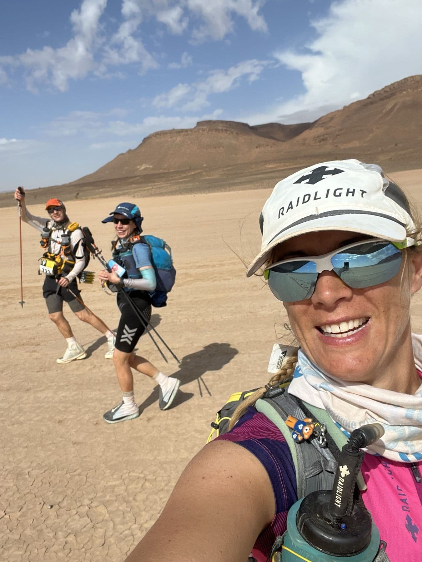 Charlotte selfie with two runners on the dry desert plain at the start of stage 3
