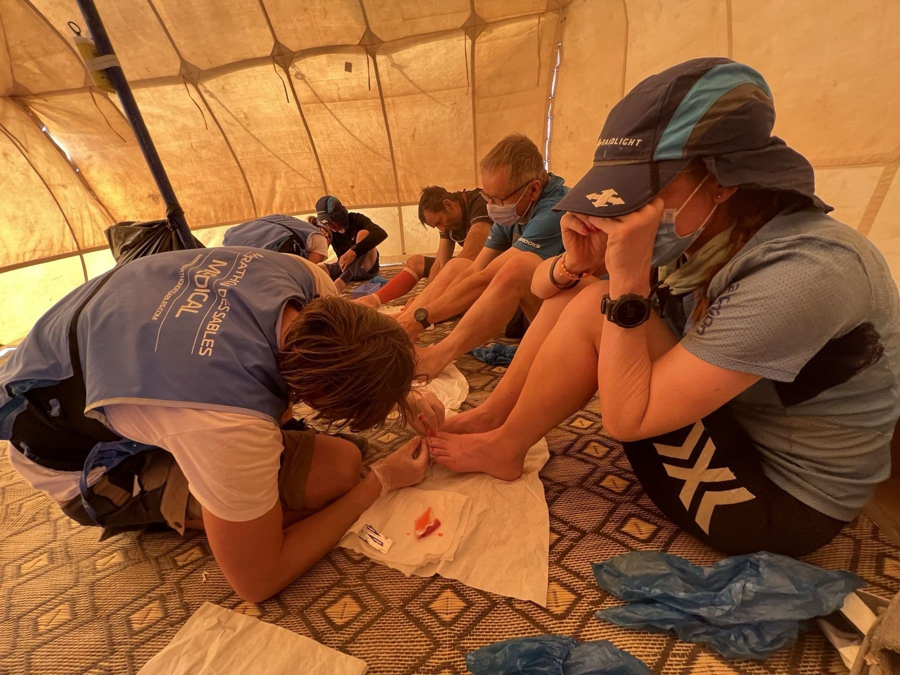 Medics treating blistered feet of runners in the Doc Trotters tent