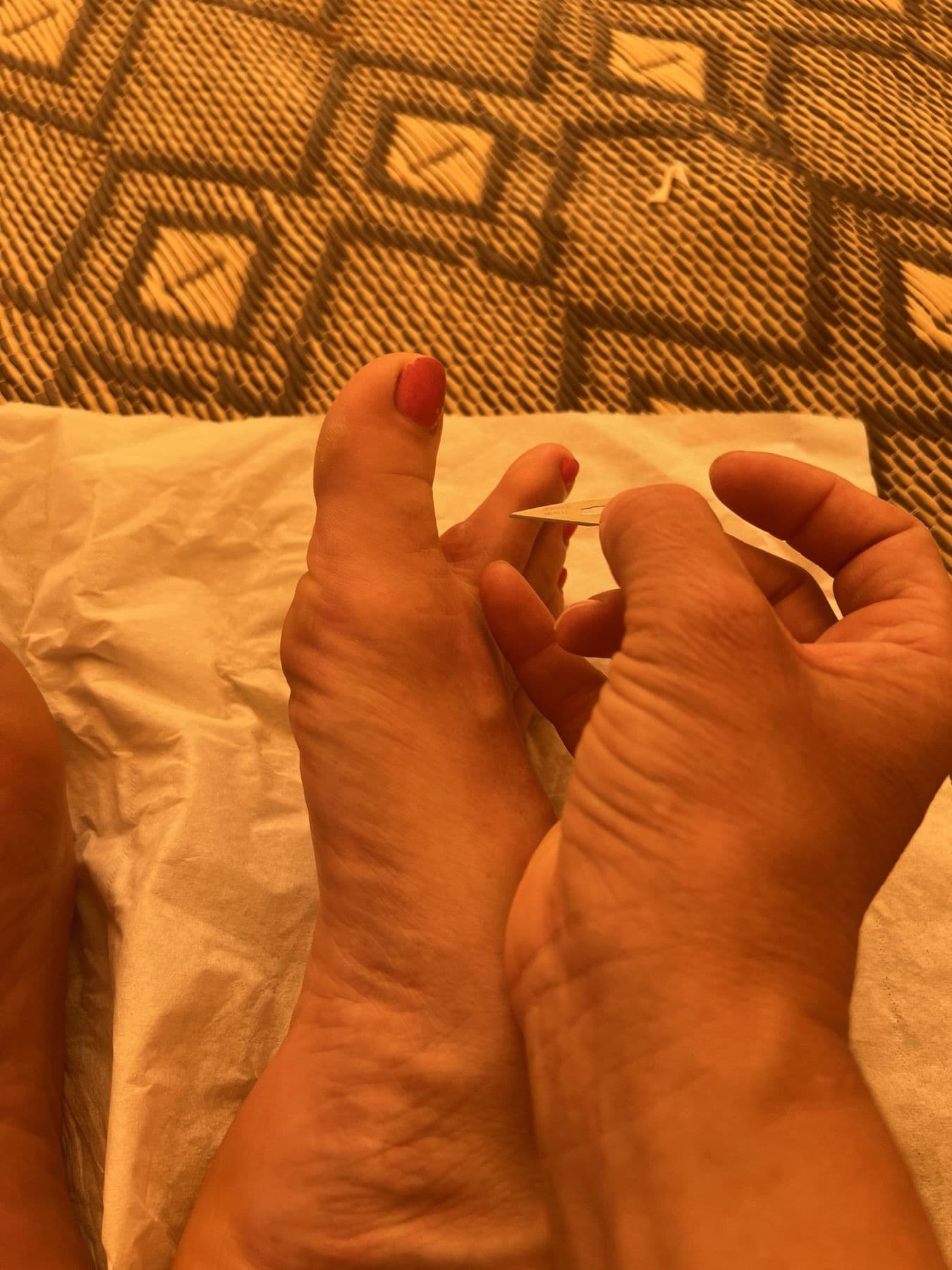 Charlotte treating a blister on her own toe with a blade in the tent
