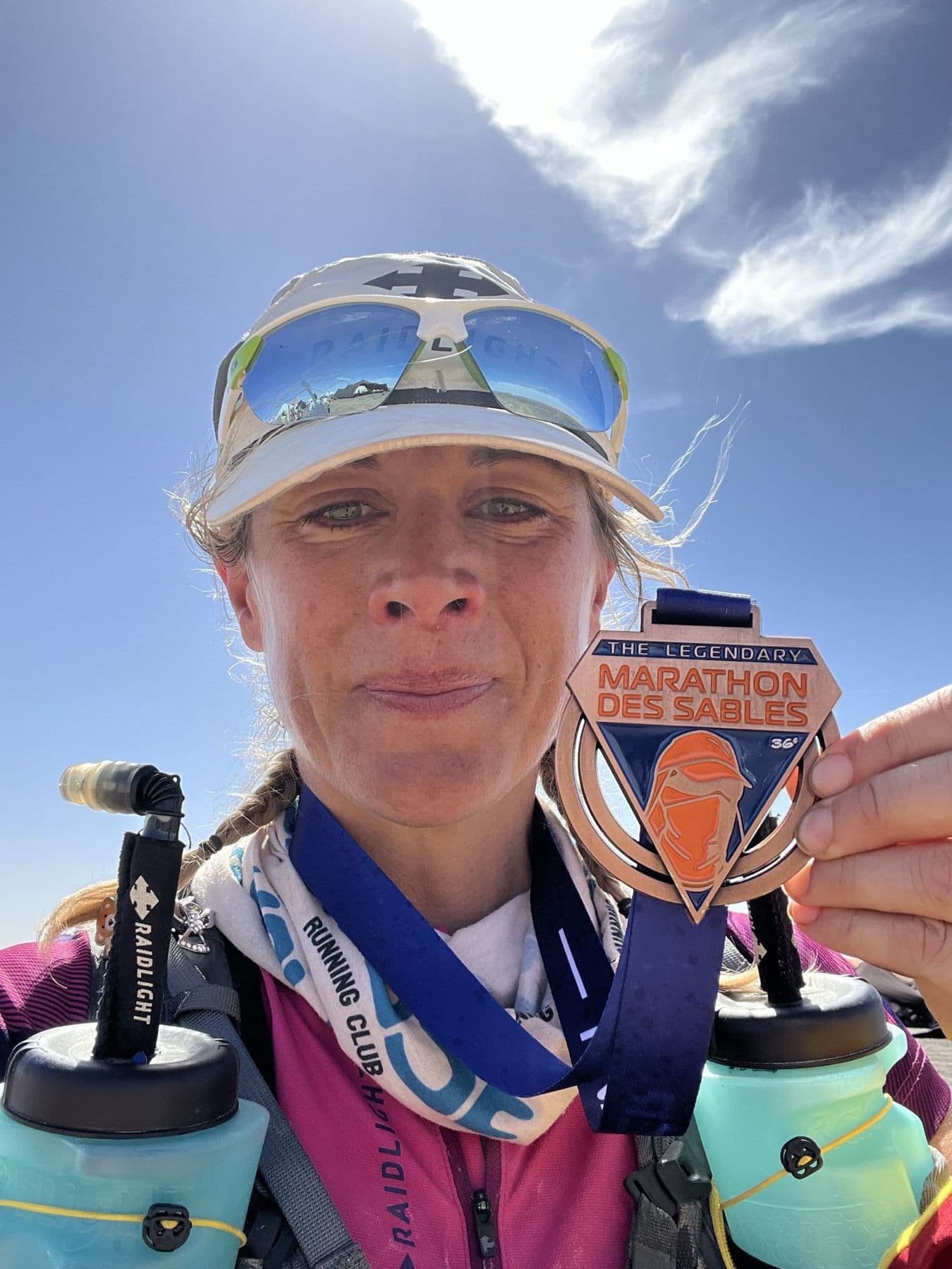 Charlotte holding up her 36th Marathon des Sables finisher medal