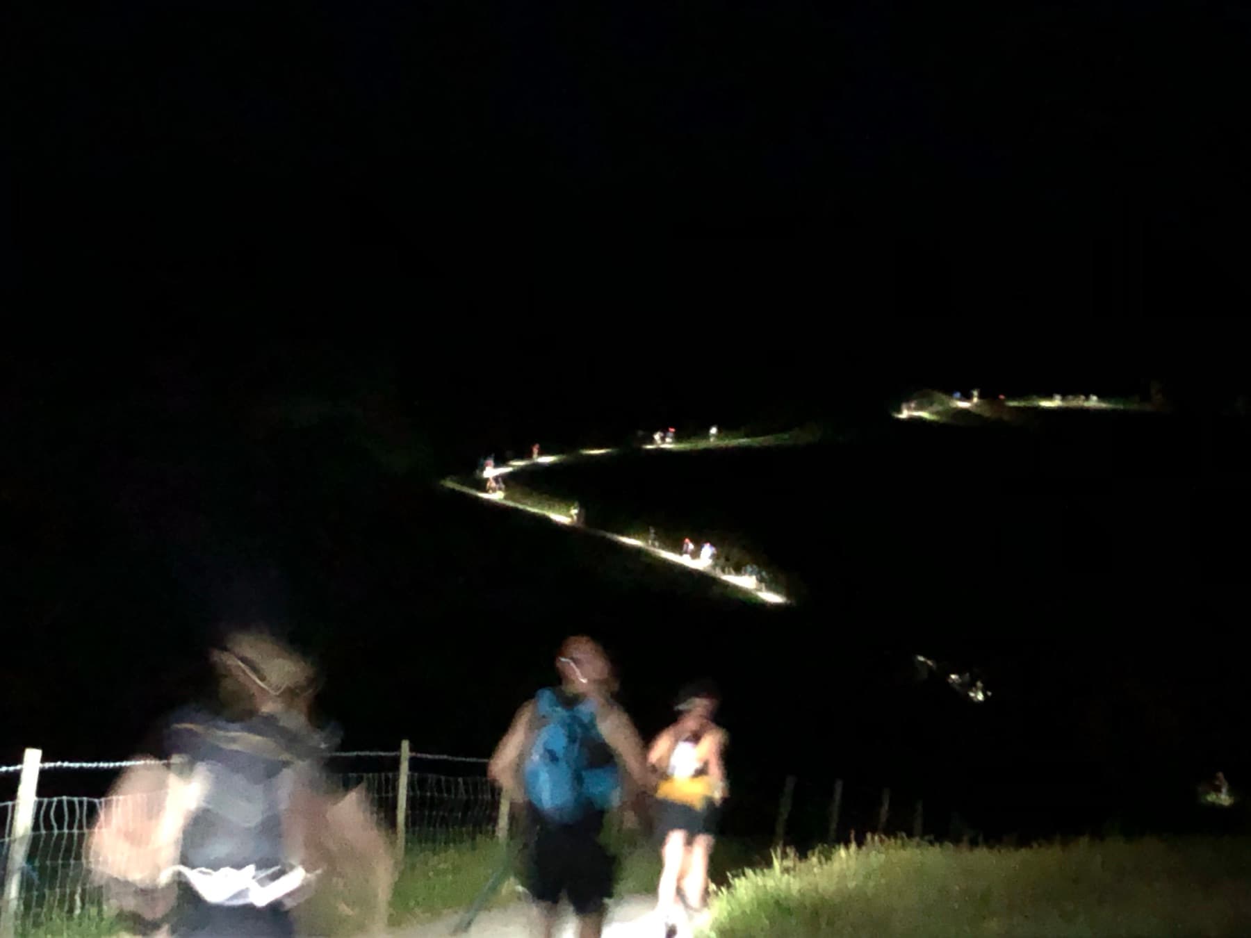 Trail of head torches winding along the path towards Kentmere in the dark