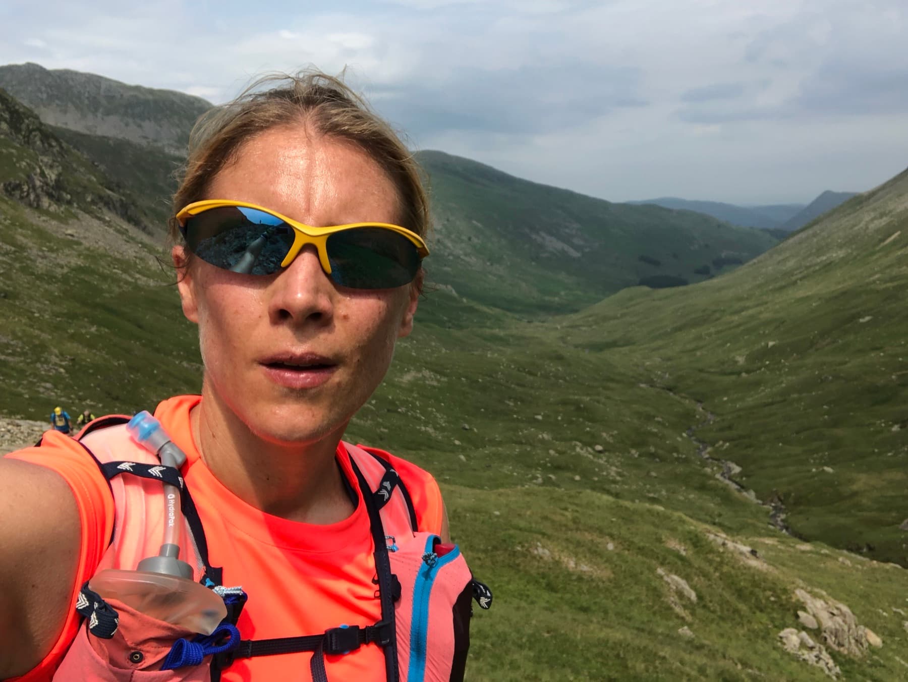 Runner selfie at the top of a pass with Lake District fells behind