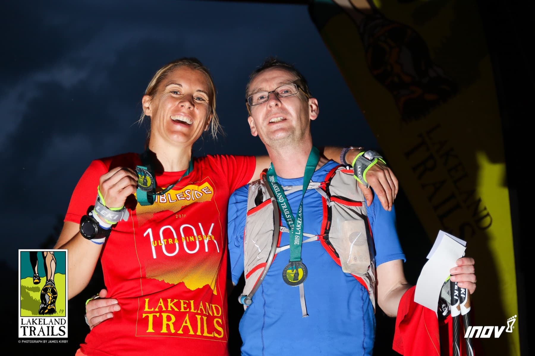 Runner and Scott celebrating with 100K ultra finisher medals at the Lakeland Trails finish