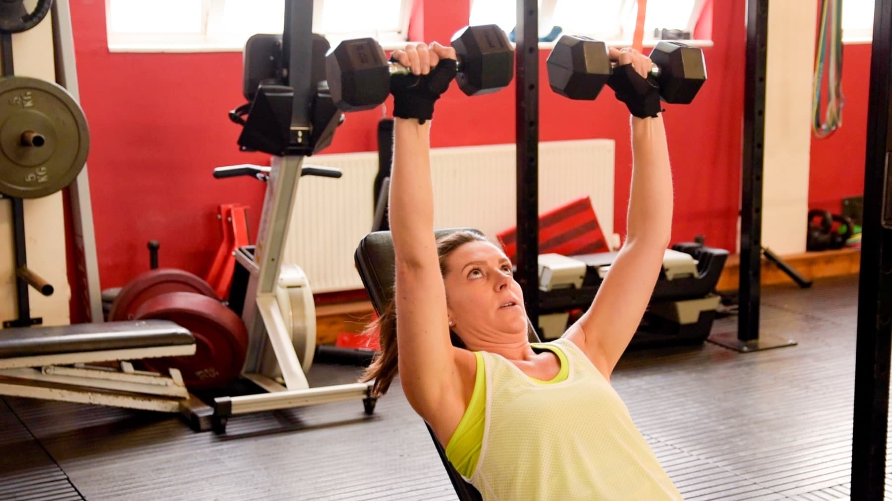 Client performing an incline dumbbell press on a bench